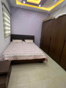 a bedroom with a bed and a purple wall at Studio de vacance à louer in Monastir