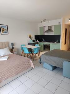 a bedroom with two beds and a table and chairs at Nice studio 5 minutes walk from the beach in Cagnes-sur-Mer