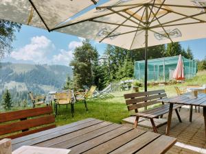 eine Terrasse mit Tisch, Stühlen und Sonnenschirm in der Unterkunft Berghütte Plafötschalm in Tiers