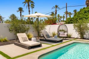 two chairs and an umbrella next to a swimming pool at Private Pool Escape Casita Mini Golf 4BR in Indio