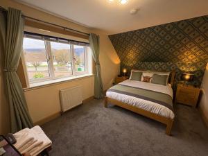 a bedroom with a bed and a large window at Kildonan House Bed and Breakfast in Corpach