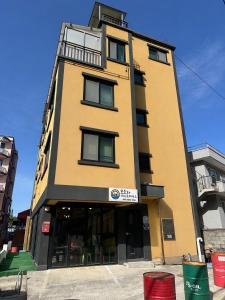 a tall yellow building with windows on a street at Osoha guest house in Samcheok