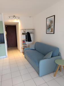a living room with a blue couch and a table at Nice studio 5 minutes walk from the beach in Cagnes-sur-Mer