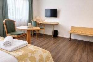 a hotel room with a bed and a table and a desk at Grüner Baum in Bad Staffelstein