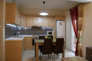 a kitchen with a table and chairs and a refrigerator at City House Apartment in Thessaloniki