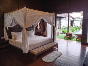 a bedroom with a canopy bed and a pool at Merlyn Meadows Retreat in Munduk +53 photos