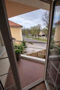an open door to a balcony with a view of a street at Apartmány Bojnický Vínny Dom in Bojnice