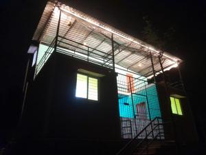 a house with lights on the side of it at night at Pani thuzhi in Salem