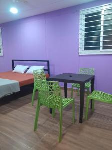 a room with a table and chairs and a bed at Pani thuzhi in Salem +9 photos