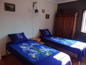 two beds in a room with blue sheets at Casa do Tamega in Amarante
