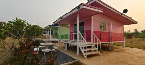 a pink house with stairs and benches in front of it at ณ กาญโฮม NaKan Home in Ban Hin Hak