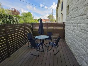a patio with a table and chairs and an umbrella at Appartement paisible in Quévert