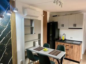 a kitchen with a table and chairs in a room at The Forest Retreat in Mihăeşti +5 photos
