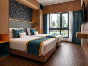 two beds in a hotel room with a window at Zone by The Park Darjeeling in Darjeeling