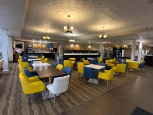 a restaurant with yellow and blue chairs and tables at Comfort Suites Scranton near Montage Mountain in Scranton