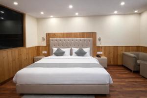 a bedroom with a large bed and a flat screen tv at Hotel The Himalayan Riverside - Most Awarded Property of Manali 2025-26 in Manāli