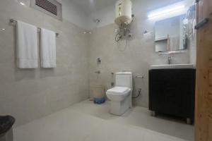 a white bathroom with a toilet and a sink at Hotel The Himalayan Riverside - Most Awarded Property of Manali 2025-26 in Manāli +20 photos