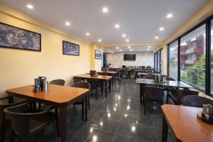 a restaurant with tables and chairs and a flat screen tv at Hotel The Himalayan Riverside - Most Awarded Property of Manali 2025-26 in Manāli