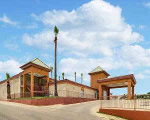 a building with a palm tree in front of a road at Econo Lodge Inn & Suites Eagle Pass in Eagle Pass