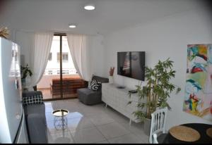 a living room with a couch and a tv at Sobre el Mar en Edificio Magallanes in El Médano