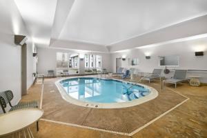 a pool in a room with chairs and tables at Spark By Hilton Hamburg in Hamburg