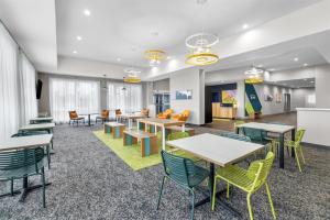 an empty waiting room with tables and chairs at Spark By Hilton Hamburg in Hamburg +44 photos