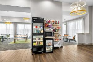 a kitchen with a refrigerator and a dining room at Spark By Hilton Hamburg in Hamburg