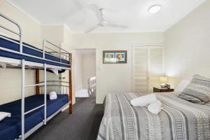 a bedroom with two bunk beds and a desk at Mango Tree Holiday Apartments in Port Douglas +89 photos