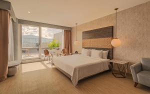 a hotel room with a bed and a large window at V Grand Hotel, a member of Radisson Individuals in Medellín +124 photos