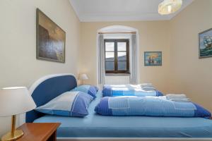a bedroom with two blue beds and a window at Schloss Berg Klösterle in Zedlitzdorf