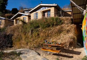 a table on the beach in front of a house at Nomad Eco Retreat in Shimla