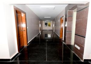 a hallway of a building with doors and tile floors at Hotel Ram Way in Visakhapatnam