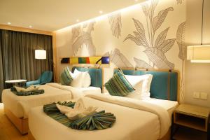 a hotel room with two beds with flowers on them at Clarion Inn Greywall By Choice Hotels in Amritsar +16 photos