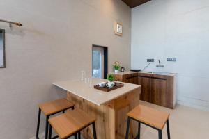 a kitchen with a island with two chairs and a sink at Kaafal Cottage in Mukteshwar +15 photos