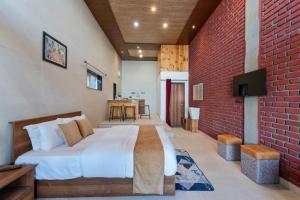 a bedroom with a large bed and a brick wall at Kaafal Cottage in Mukteshwar