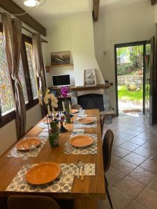 a dining room with a wooden table with plates and utensils at La villetta tra ulivi e colline in Civezza