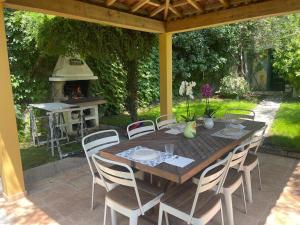a wooden table and chairs on a patio with a grill at La villetta tra ulivi e colline in Civezza