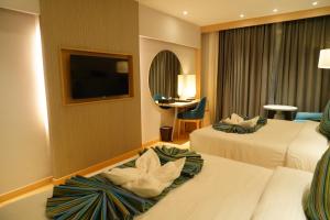 a hotel room with two beds and a flat screen tv at Clarion Inn Greywall By Choice Hotels in Amritsar