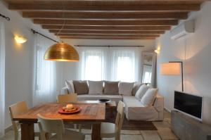 a living room with a white couch and a table at Aegea Blue Cycladic Resort in Zorgos 