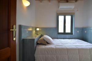 a bedroom with a bed with a window at Aegea Blue Cycladic Resort in Zorgos 