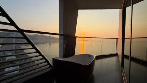 a chair sitting on a balcony with a view of the water at Boton Blue Hotel & Spa in Nha Trang
