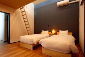 a bedroom with two beds and a ladder on the wall at Nord SUR in Ichinomiya +42 photos