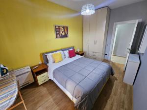 a bedroom with a bed in a room with yellow walls at central apart in Tirana