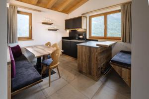 a kitchen with a wooden table and a dining room at Schmalzlhof in Siusi