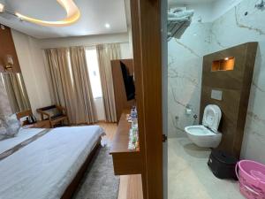 a hotel room with a bed and a toilet at The Kridha Palace in Ayodhya