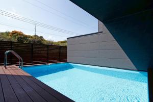 a swimming pool on a deck next to a house at Nord SUR in Ichinomiya