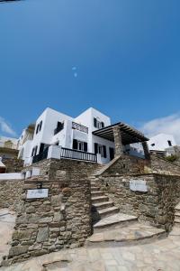 a house on top of a stone wall at To Pelagos in Agios Sostis
