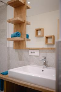 a bathroom with a white sink and a mirror at Schmalzlhof in Siusi +37 photos
