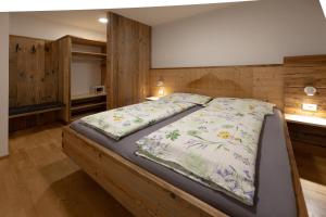a bedroom with a large bed with a blanket at Schmalzlhof in Siusi