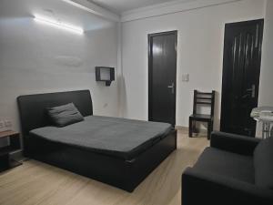 a bedroom with a black bed and a chair at Home By The Park in New Delhi